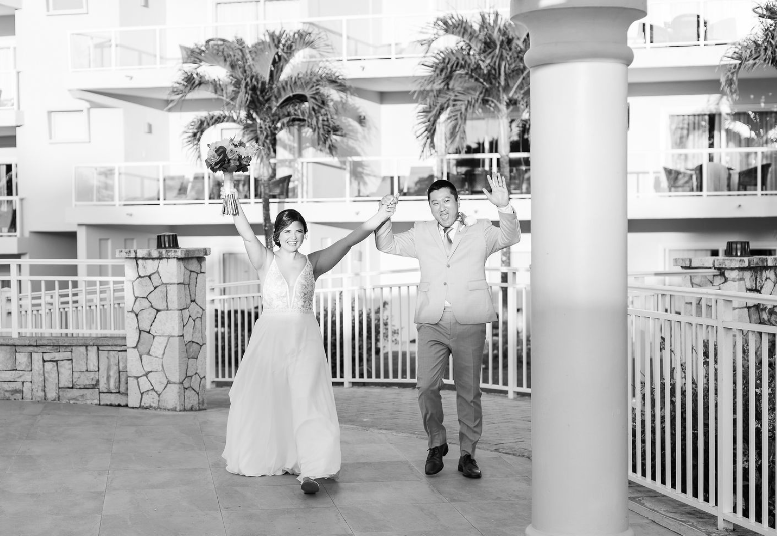 Bride and groom excited holding hands and hands up