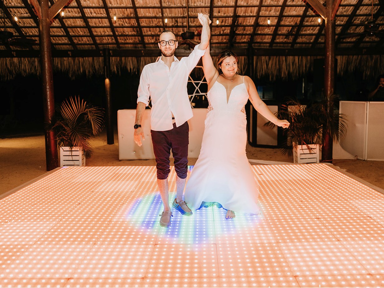 Bride and groom dancing on an LED-lit dance floor during their reception