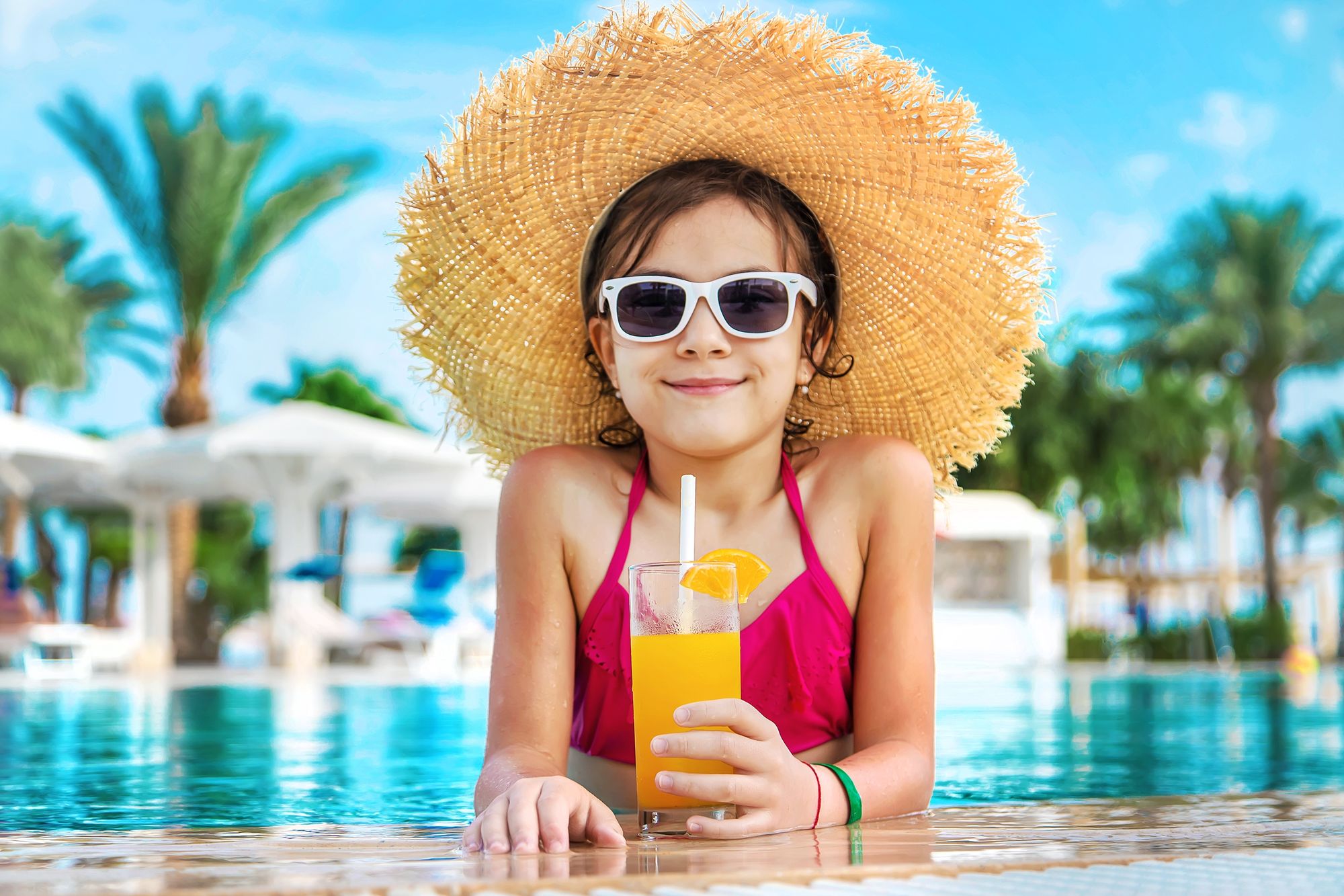 little girl in pool with drink