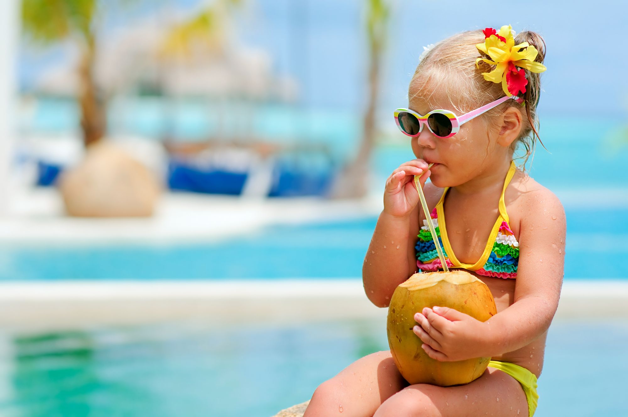 little girl drinking from coconut